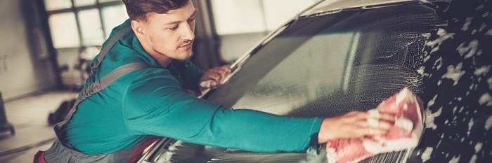 man washing car in garage